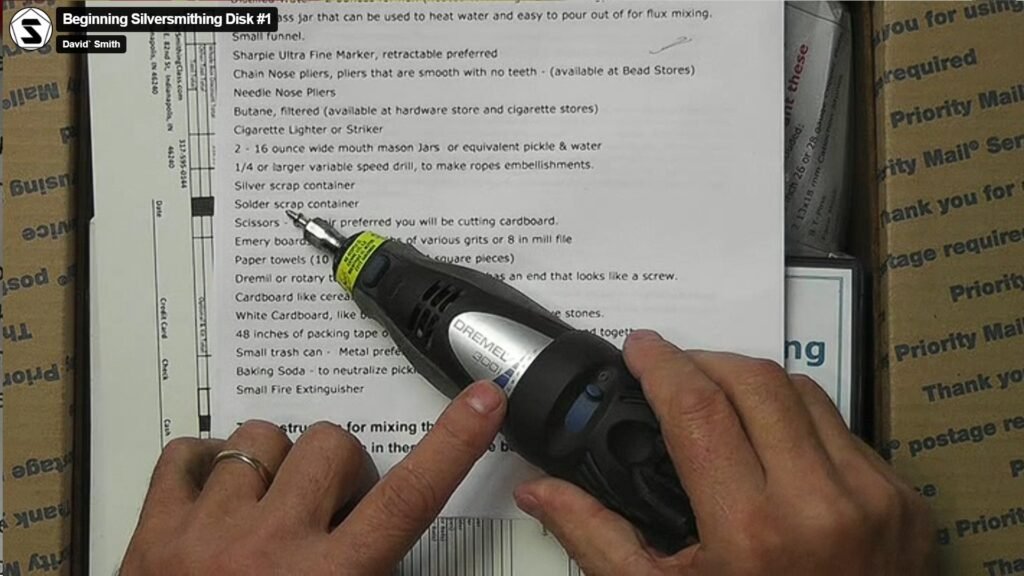 Dremel rotary tool on silversmithing workbench with polishing wheel attached