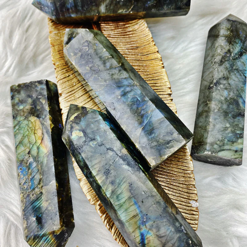 Polished labradorite cabochon flashing electric blue and green labradorescence